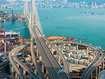 a bridge over water with a city in the background
