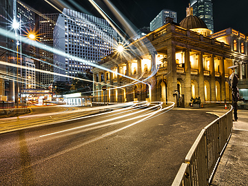 a street with lights and a building in the background